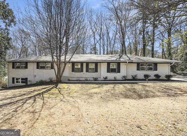 ranch-style house featuring brick siding