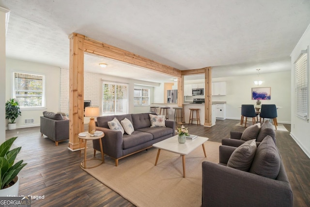 living room featuring visible vents, baseboards, and dark wood-type flooring