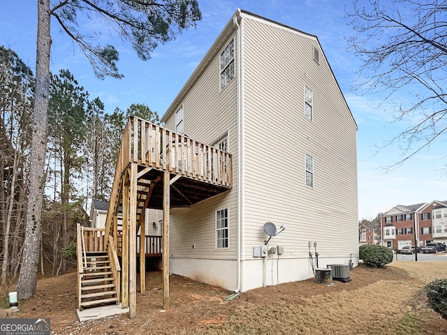 exterior space with cooling unit, a wooden deck, and stairs