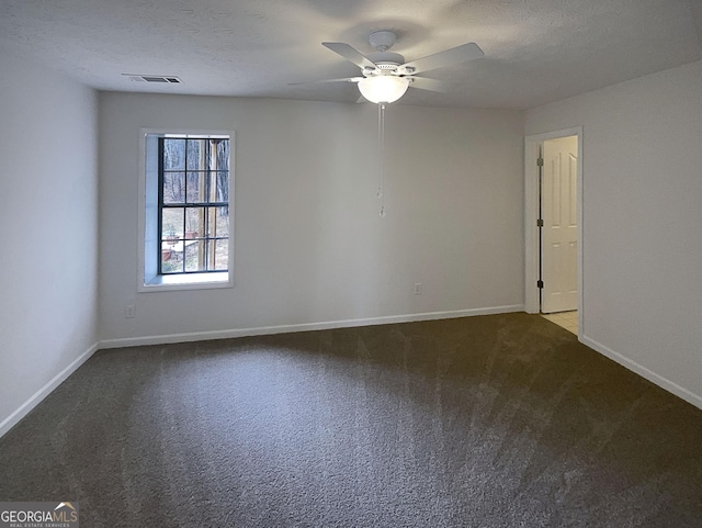 carpeted spare room featuring baseboards, visible vents, and a textured ceiling