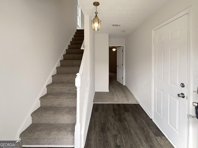 stairs featuring visible vents, baseboards, and wood finished floors