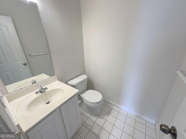 bathroom with tile patterned floors, baseboards, toilet, and vanity