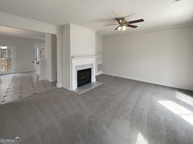 unfurnished living room with a ceiling fan, visible vents, carpet floors, a fireplace, and ornamental molding