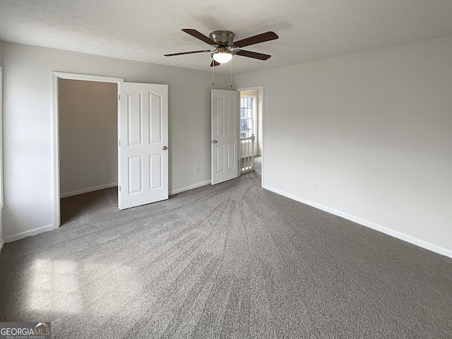 unfurnished bedroom with carpet flooring, a ceiling fan, and baseboards