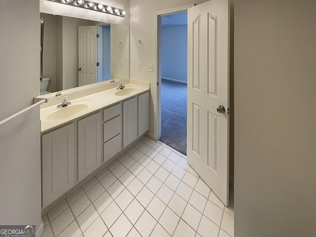 full bathroom featuring double vanity, tile patterned flooring, toilet, and a sink