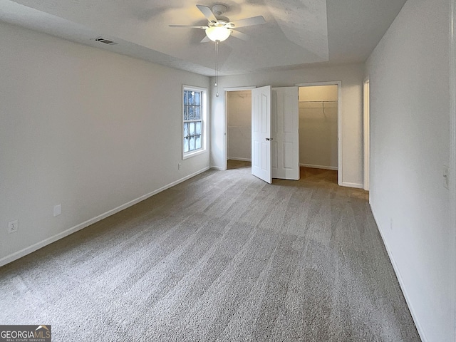 unfurnished bedroom with visible vents, baseboards, a ceiling fan, and carpet flooring