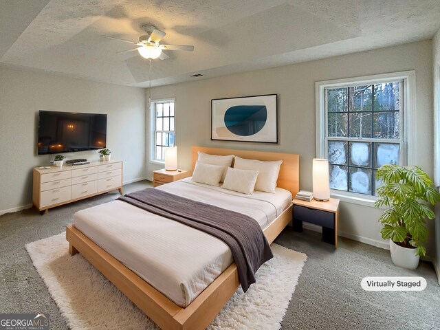 bedroom with baseboards, a textured ceiling, ceiling fan, and carpet