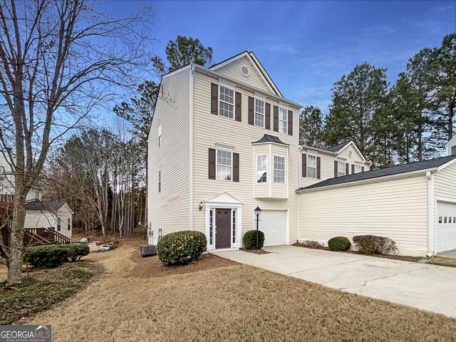 view of front of home with central air condition unit, driveway, and an attached garage