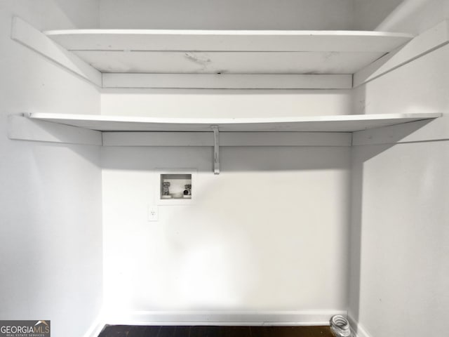 clothes washing area featuring baseboards, washer hookup, and laundry area