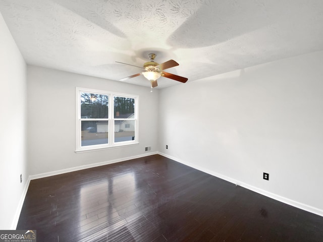 unfurnished room with visible vents, a ceiling fan, baseboards, and dark wood-style flooring