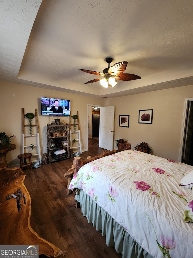 bedroom featuring a textured ceiling, a ceiling fan, and wood finished floors