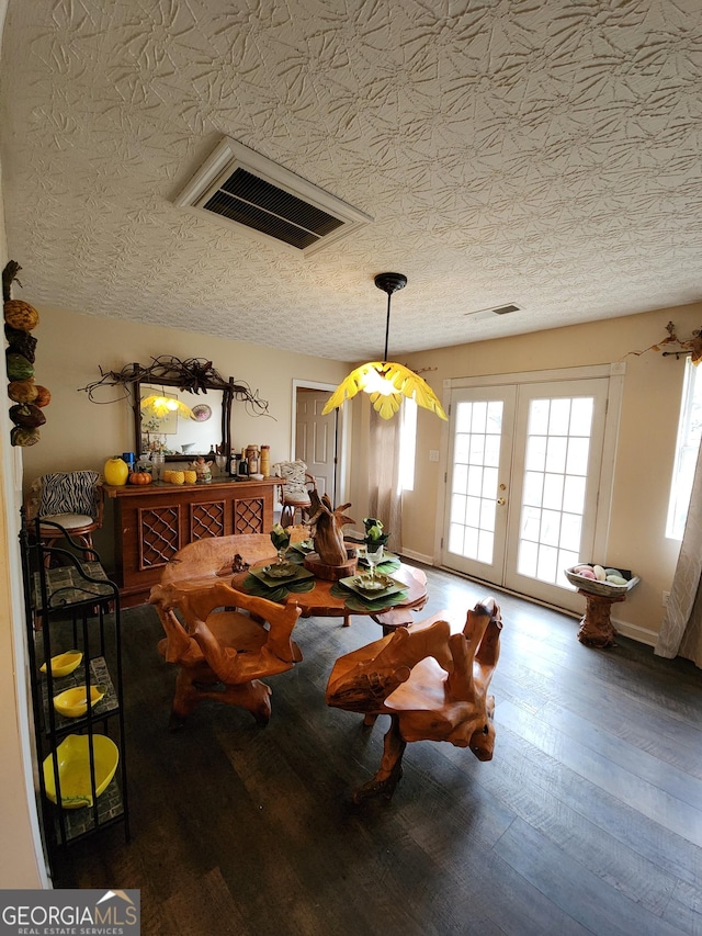 sitting room featuring french doors, a textured ceiling, visible vents, and wood finished floors