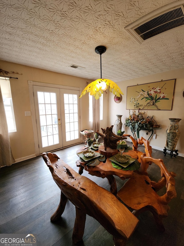 dining area featuring visible vents, a healthy amount of sunlight, french doors, and hardwood / wood-style flooring