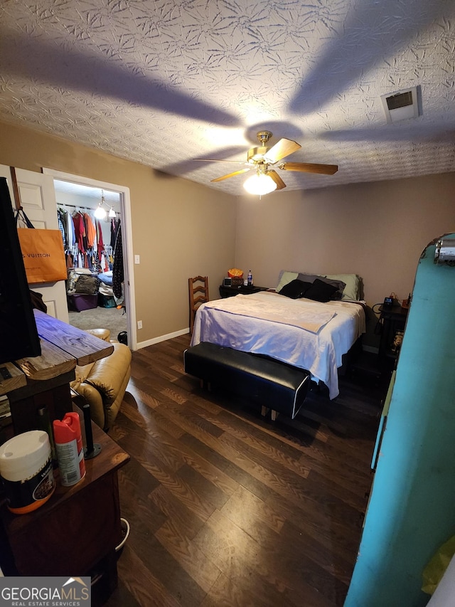 bedroom with a ceiling fan, wood finished floors, visible vents, arched walkways, and a textured ceiling