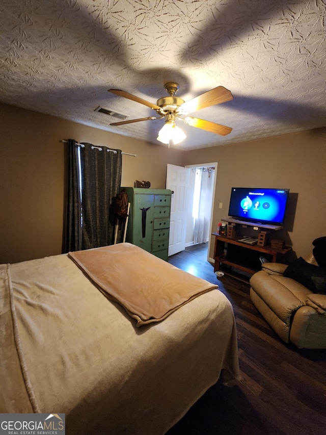 bedroom featuring visible vents, a textured ceiling, and a ceiling fan