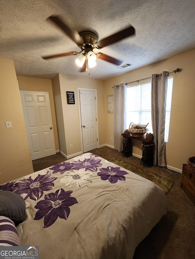 bedroom featuring a ceiling fan, baseboards, visible vents, and a textured ceiling