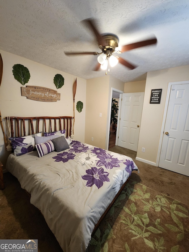 carpeted bedroom featuring baseboards, a textured ceiling, and ceiling fan