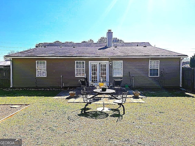 back of house with a patio area, a lawn, a chimney, and fence