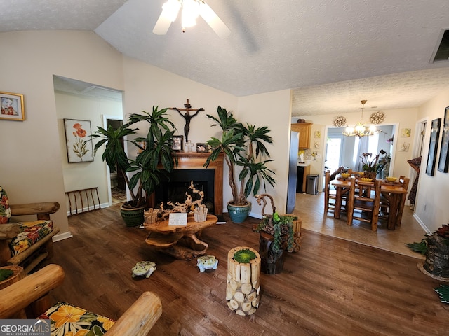 living area featuring lofted ceiling, a textured ceiling, wood finished floors, and a fireplace