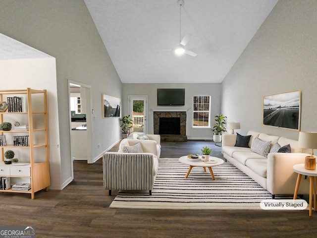 living area featuring a stone fireplace, high vaulted ceiling, wood finished floors, and ceiling fan