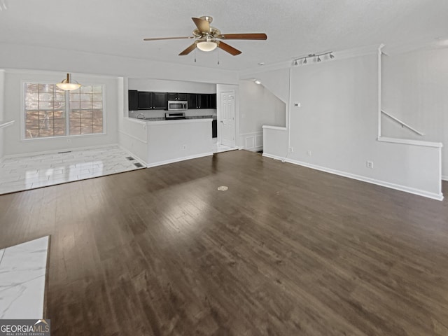 unfurnished living room featuring ceiling fan and dark wood finished floors