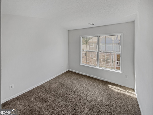 unfurnished room featuring carpet flooring, visible vents, a textured ceiling, and baseboards