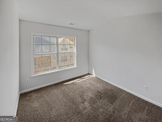 unfurnished room with baseboards, carpet floors, a textured ceiling, and visible vents