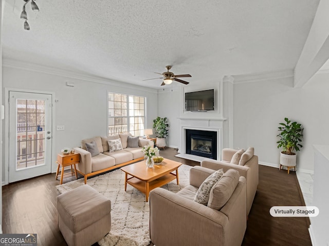 living room with a fireplace with flush hearth, a textured ceiling, a healthy amount of sunlight, and wood finished floors