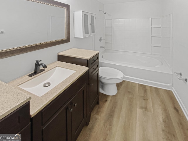 full bath featuring vanity, bathing tub / shower combination, toilet, and wood finished floors