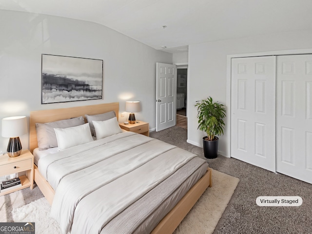 carpeted bedroom with a closet, baseboards, and vaulted ceiling