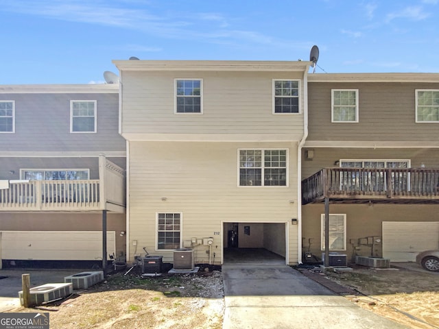 rear view of property with central air condition unit and driveway