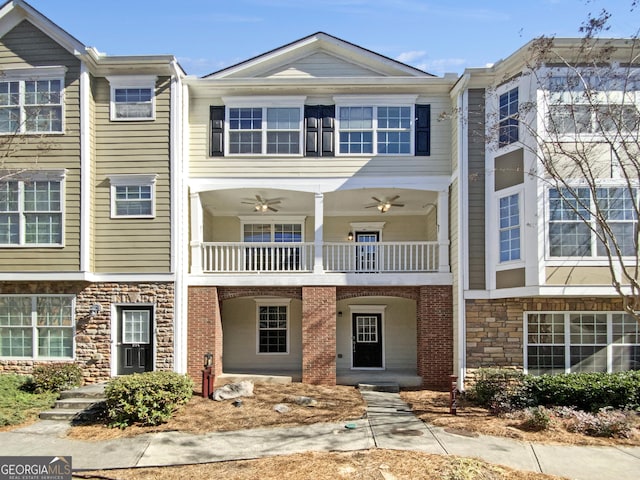 multi unit property featuring stone siding, a ceiling fan, and a balcony