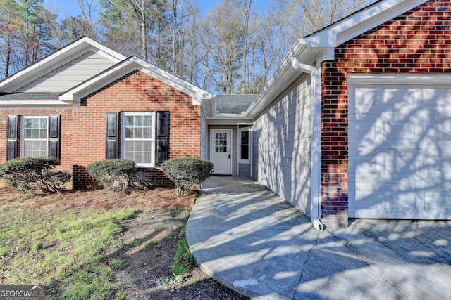 exterior space with a garage and brick siding