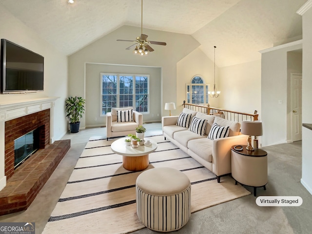 living area featuring ceiling fan with notable chandelier, a brick fireplace, baseboards, and vaulted ceiling