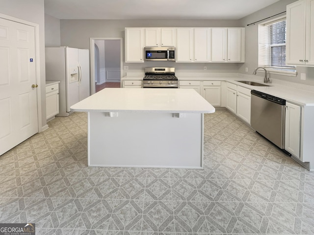 kitchen with light floors, appliances with stainless steel finishes, light countertops, and a sink