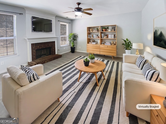 living area with a fireplace, baseboards, and ceiling fan