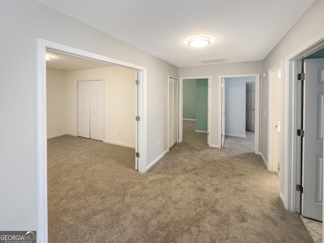 interior space with baseboards, carpet floors, and visible vents