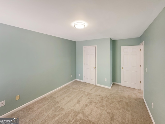 unfurnished bedroom with carpet flooring and baseboards