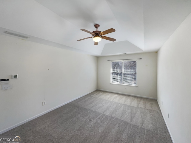 empty room with baseboards, visible vents, ceiling fan, a raised ceiling, and carpet flooring