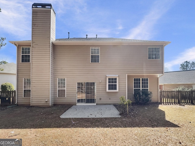 back of house featuring a patio, a chimney, and fence