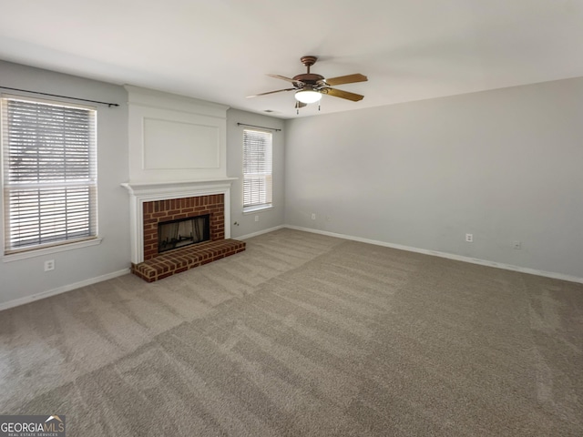 unfurnished living room with plenty of natural light, a fireplace, and light colored carpet