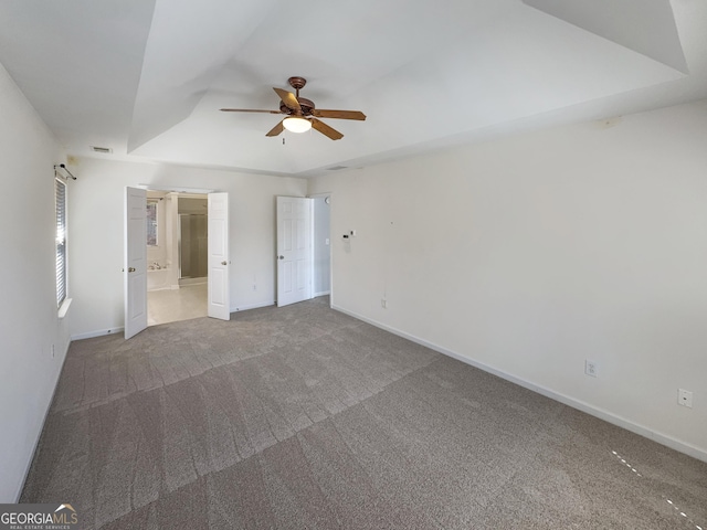 unfurnished bedroom featuring visible vents, ceiling fan, baseboards, carpet floors, and ensuite bathroom