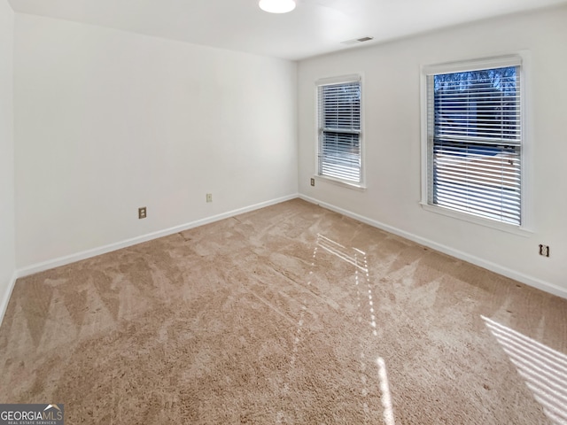 unfurnished room with visible vents, carpet flooring, and baseboards