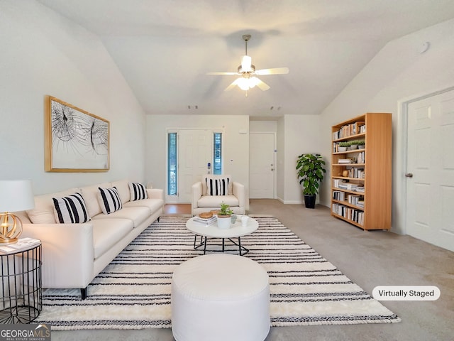 living area featuring lofted ceiling, carpet flooring, and a ceiling fan