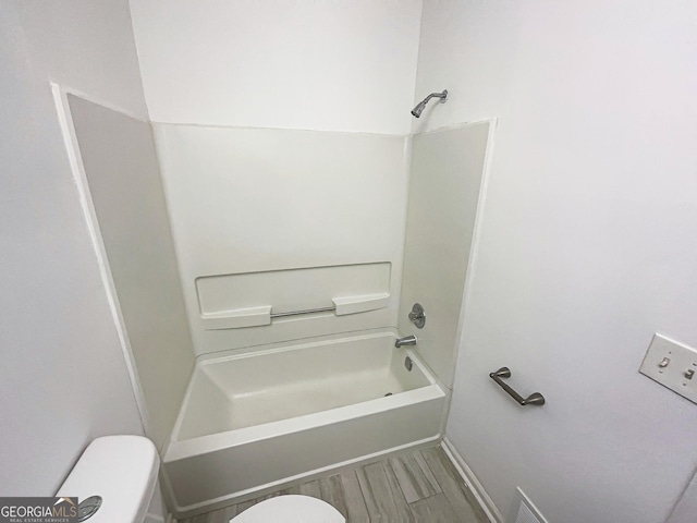 full bathroom with tub / shower combination, toilet, and wood finished floors