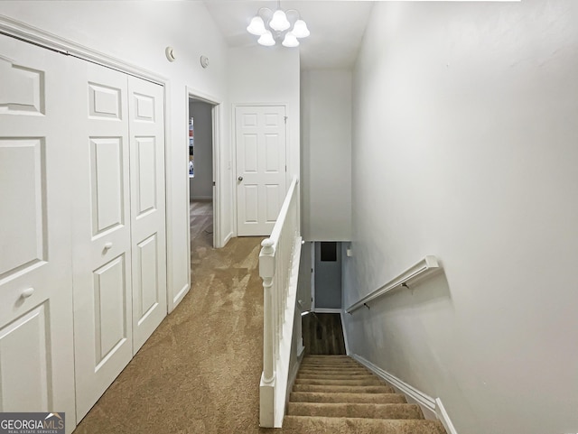 stairs featuring baseboards, carpet floors, and a notable chandelier