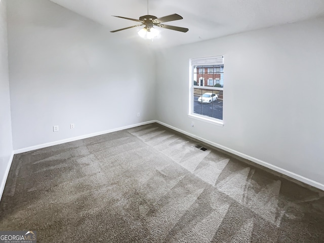 carpeted empty room featuring visible vents, baseboards, and ceiling fan