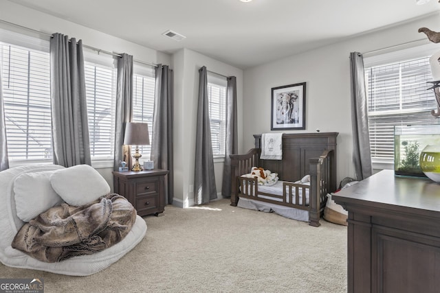 bedroom with light colored carpet, visible vents, and baseboards