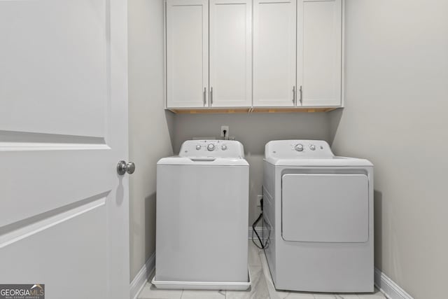 laundry area with washer and dryer, cabinet space, and baseboards