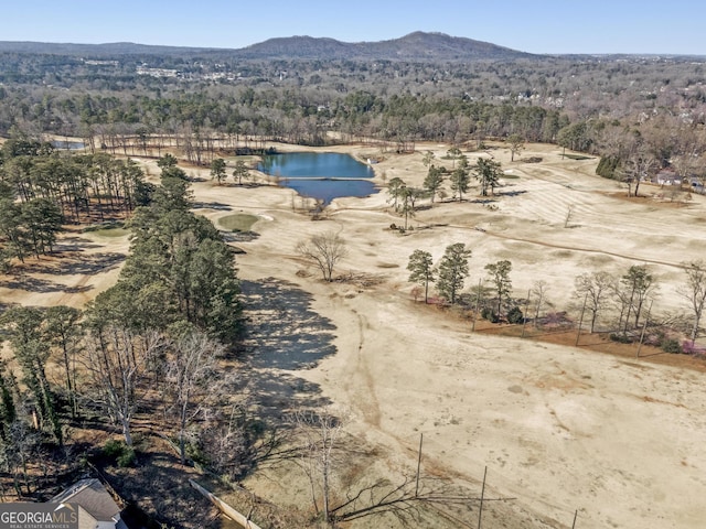 birds eye view of property featuring a wooded view and a water and mountain view